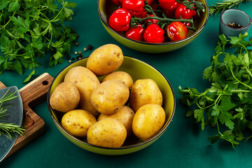Fresh raw potatoes and bunch of wet ripe tomatoes.