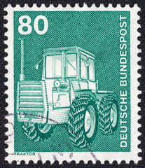 Farm tractor on a 1975 Germany vintage postage stamp. Industry and Technology Series