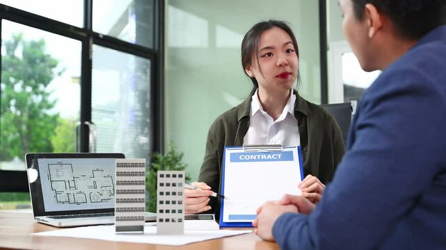 Real estate agent presenting floorplan to client with building models. Business consultation, investment planning