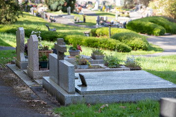 Vue de tombes fleuries et décorées dans un cimetière de ville. Cela permet de rendre hommage au défunt et de témoigner son attachement et le respect envers cet être cher.