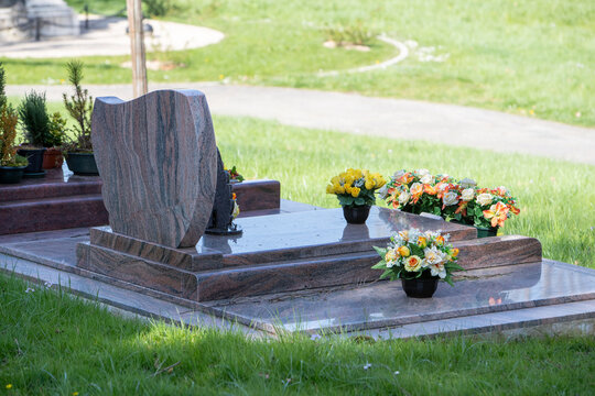 Le fleurissement d&rsquo;une tombe avec un bouquet de fleurs orange. Cela permet de rendre hommage au d&eacute;funt et de t&eacute;moigner son attachement et le respect envers cet &ecirc;tre cher. 