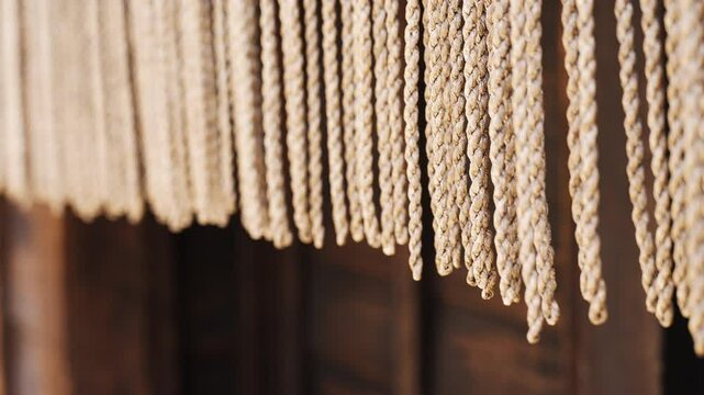 Textured woven rope curtain hanging in front of a doorway.