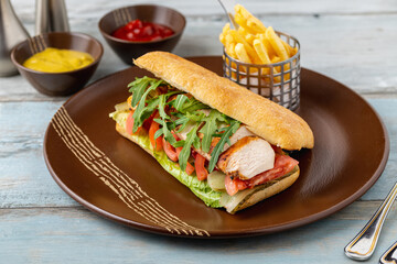 Grilled chicken breast sandwich with french fries and sauces