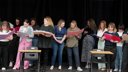 Group of local amateur theatre performers rehearsing together on stage