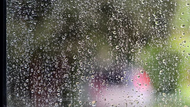 ripresa video in tempo reale con inquadratura macro del vetro di una finestra durante un temporale, in primo piano, mentre viene bagnato con gocce di pioggia