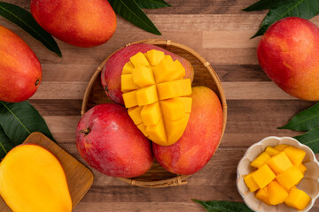 Fresh ripe mango with cubes on wooden table background.