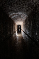 inquadratura verticale e panoramica di un lungo corridoio all'interno di un antico bunker...