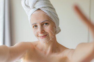 Young woman relaxing at home with a hydrating facial sheet mask.  kincare routine, beauty...