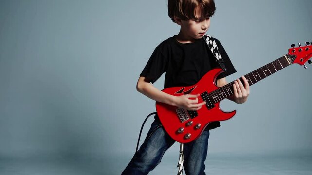 Young boy passionately playing red electric guitar in studio, symbolizing childhood creativity, music education, rock and roll dreams, youth expression, artistic growth, and musical talent development