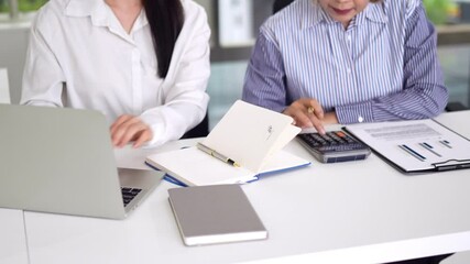 Asian Senior Business Leader Guiding Adult Asian Candidate During Interview Session in a Collaborative Office Environment