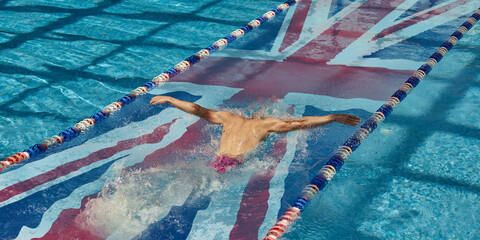 Male swimmer captured mid-butterfly stroke in a pool lane featuring English flag. Concept of...