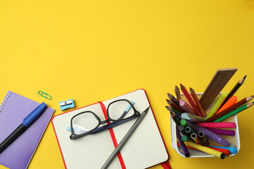 Children school supplies flat lay on yellow background with copy space