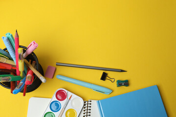 Children school supplies flat lay on yellow background with copy space
