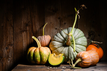 Decorative autumn pumpkins in different shapes set on vintage wooden surface. Cozy country scene...