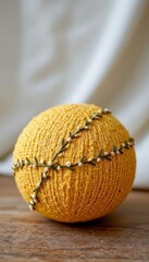 Yellow Embroidered Sphere on Wooden Surface