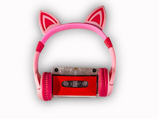 headphones for listening to music, wireless, pink color with funny ears and a cassette. music concept