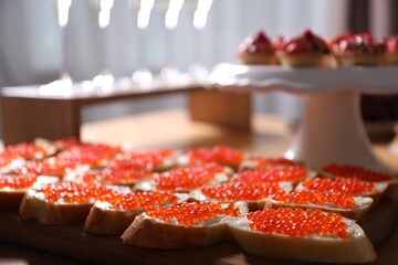 Buffet menu. Tasty sandwiches with red caviar on table, closeup