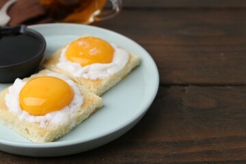 Traditional asian breakfast with tasty kaya toasts and half-boiled eggs served on wooden table,...