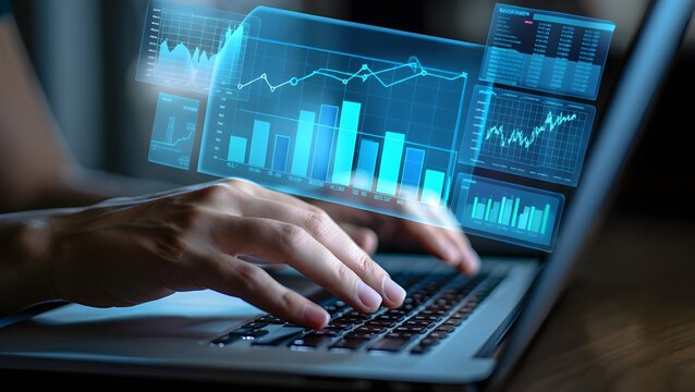 Hands typing on laptop with futuristic holographic financial data charts and graphs