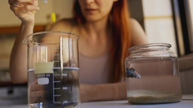 Woman preparing water for betta fish in fishbowl