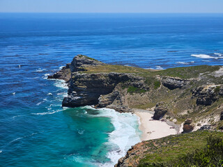 Beautiful beach with a rocky shoreline and a body of water. The water is a deep blue color, and the...
