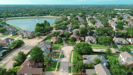 Aerial view upscale neighborhood in master-planned community near Dallas Fort Worth, Texas, waterfront Rheudasil Park two-story homes, cul-de-sac streets, large backyards, swimming pools, trees