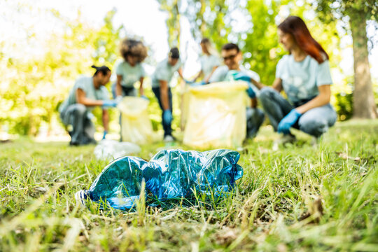 Group of volunteer cleaning picking up plastic litter in the park - Diverse group of people collect trash in the forest - Environmental protection, non profits organization and save the planet concept