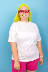 Confident Young Woman In White T-Shirt And Pink Shorts On Blue Background