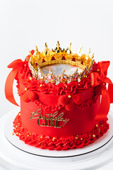 Beautiful queen or princess themed red cake . Luxury lambeth style birthday cake decorated with vintage cream tracery and golden crown. White background.