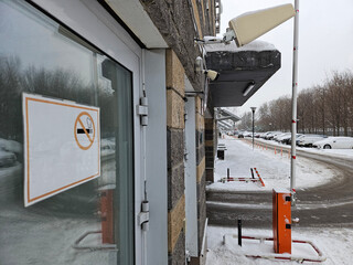 Sign on a building that says No smoking. The sign is in Russian near entrance hall housing estate...