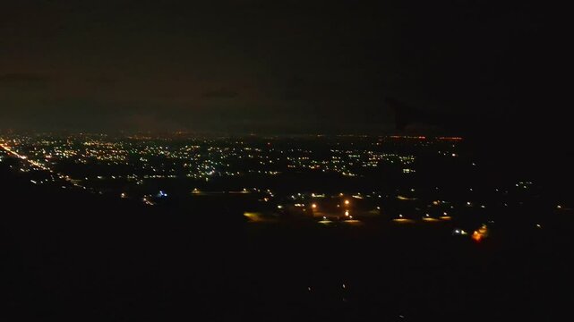 Night flight in Indonesia from Soekarno Hatta airport, Jakarta to Kualanamu, Medan. Dark mode with light points on buildings, street lights, transportation and various lights from the ground. 