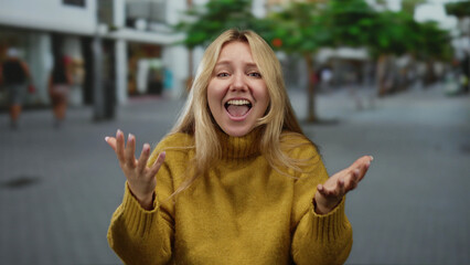 Woman gesturing on a busy city street, blonde wearing a mustard sweater, expressing emotions in an...