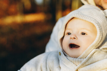 Happy cute baby son smiling in fathers hands in soft evening light in autumn woods. Fatherhood....