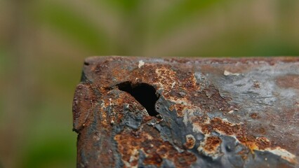 Macro shot of rusted metal with hole and peeling surface, showcasing corrosion details perfect for...