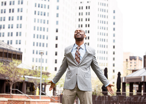 Young businessman taking a deep breath outside corporate office