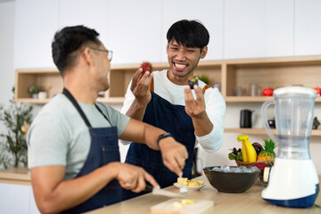LGBT couple exploring fresh fruits while cooking