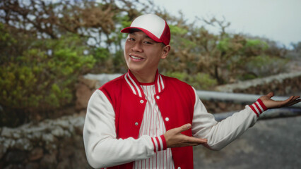 Young man in baseball uniform gestures in an outdoor park setting with a smile, showcasing the...