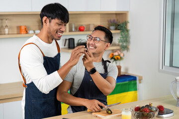 LGBTQ Couple Sharing Fun Cooking Moment in Kitchen