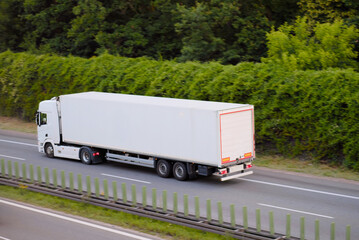 White Cargo Truck with Enclosed Trailer Driving on Highway Near Forest