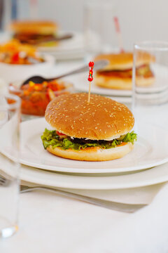 Naklejki A burger on a plate with a funny skewer.