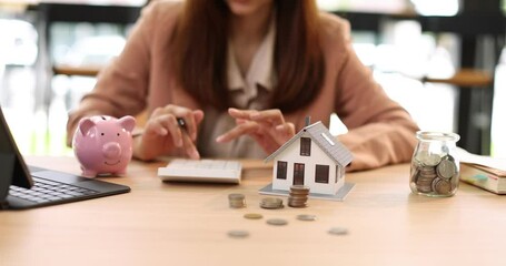 Hand plans home refinance. Pressing calculators, House model, buy or rent, calculators on desk. Saving for property purchase, optimal mortgage payment. Tax, credit analysis for financial planning.