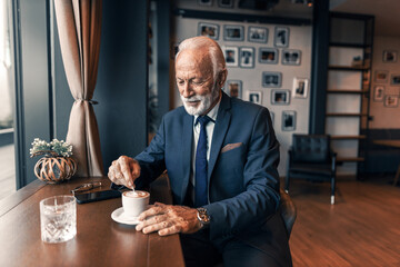 Mature Man Enjoying Coffee in a Stylish Modern Cafe
