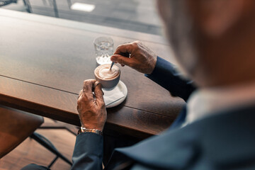 Close-Up of Man Stirring Coffee in a Coffee Shop