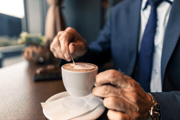 Formal Individual Stirring Coffee at a Cafe Table