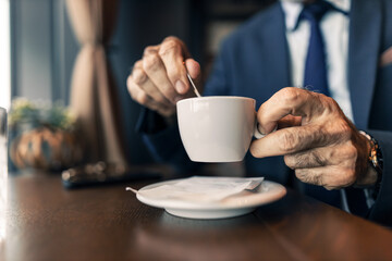 Businessman Stirring Coffee in a Stylish Cafe Setting