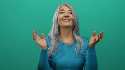 Senior woman with grey hair clapping against an isolated green background wall, smiling warmly in a...