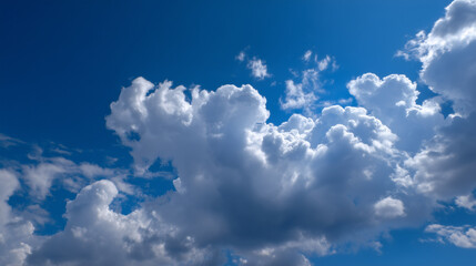 Fluffy cumulus clouds drift across a vibrant blue sky.