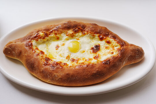 Delicious adjarian khachapuri with melted cheese and egg served warm