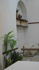 Cozy restaurant interior with plants white walls shelves and seating area creating a serene...