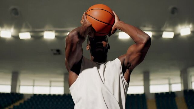 Professional basketball player practicing free throws with precision, perfecting shooting technique while standing alone in empty arena, highlighting concentrated performance and athletic skill
